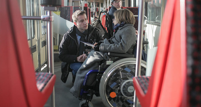 Rollstuhlfaher mit Begleiter im Bus